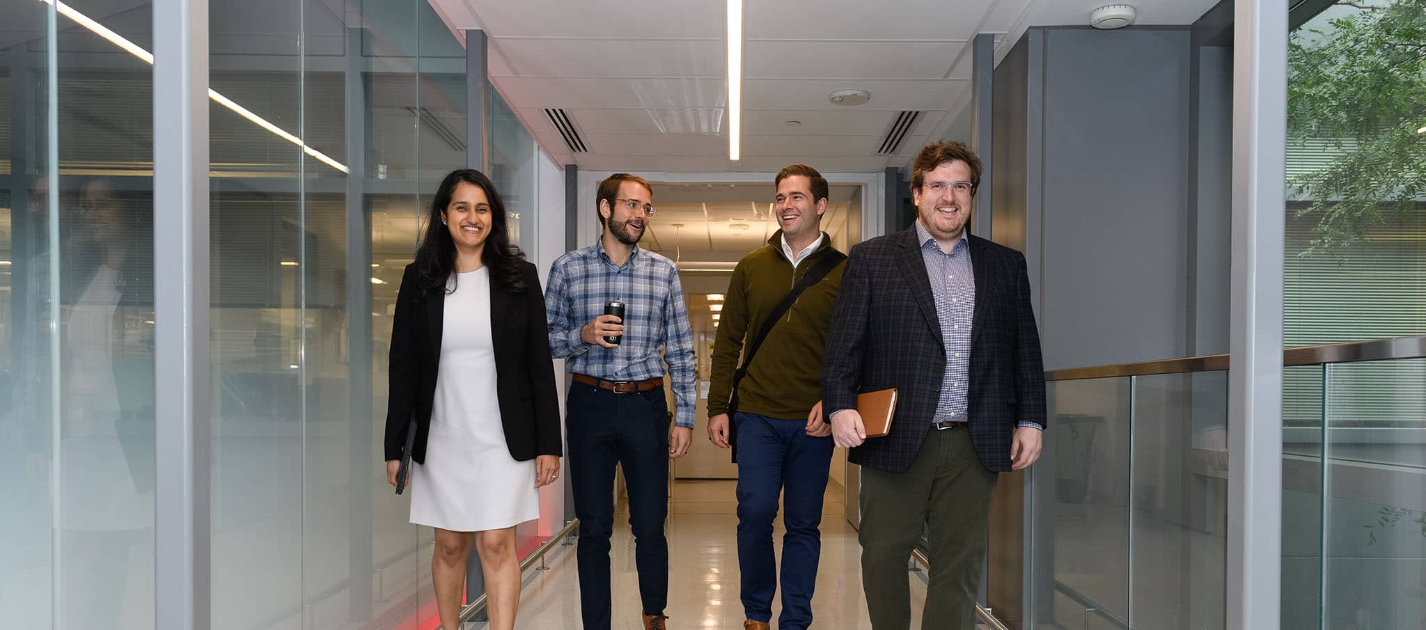 Four colleages walking down the hall.